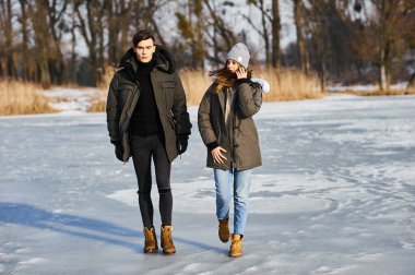 Mutlu çift kışın dışarıda sarılıp gülüyor.