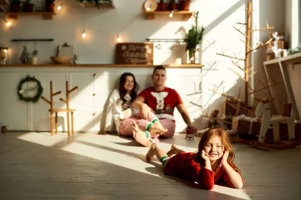 Retrato de familia feliz en pijama en la cocina cerca del árbol de Navidad —  Fotos de Stock