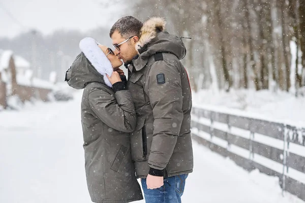 A portrait of kissing couple in winter park — Stock Photo, Image