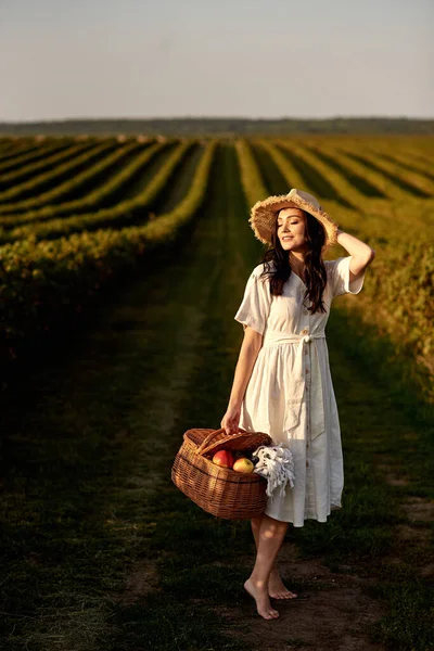 Dziewczyna z koszem spaceruje w środku zielonej plantacji. — Zdjęcie stockowe