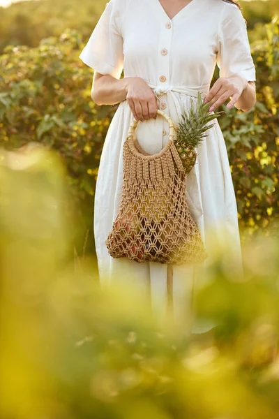 Meisje met een rieten zak met fruit. — Stockfoto