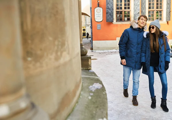 A trendy young couple walks in the city at christmastime