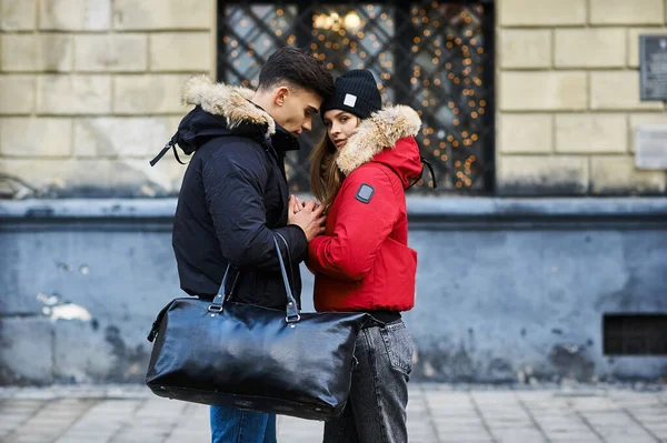 A trendy young couple walks in the city at christmastime