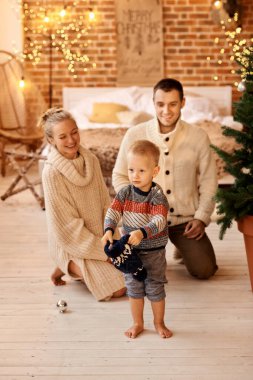 Genç aile babası, anne ve küçük oğulları mutfakta oynayıp yemek pişiriyorlar.