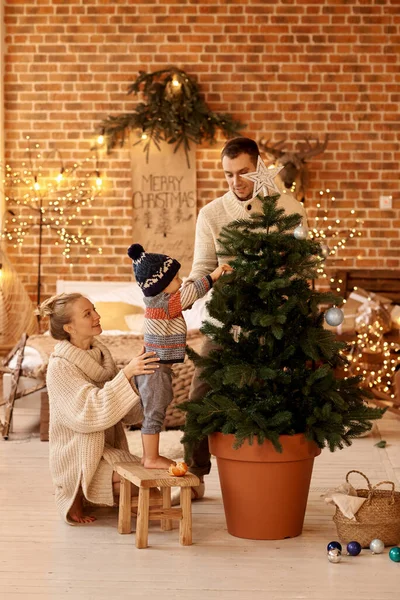 Feliz joven familyin dormitorio decora el árbol de Navidad — Foto de Stock