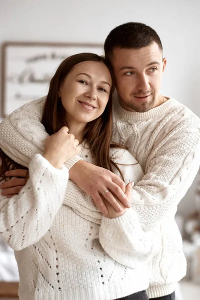 Šťastný mladý ženatý pár objímající na pozadí zdobené vánoční stromeček. — Stock fotografie