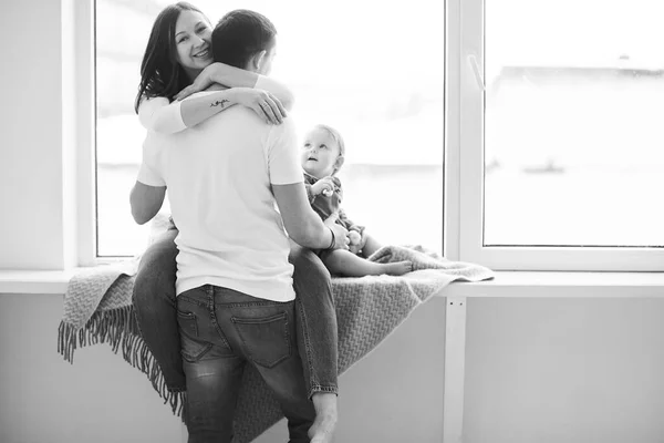 Küçük kızıyla mutlu bir ailenin portresi. Parlak odada pencerenin önünde poz veriyor.. — Stok fotoğraf