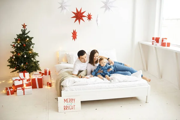 Mutlu anne baba ve kız Noel sabahı yatak odasındaki yatakta oynuyorlar.. — Stok fotoğraf