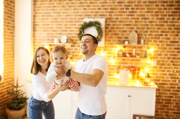 Julbakgrund. Ung familj med ett litet barn som har roligt på julen hemma. — Stockfoto