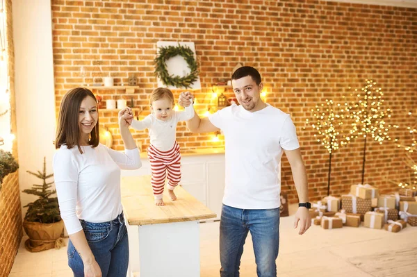 Junge Familie mit kleinem Kind genießt Weihnachten zu Hause in einem gemütlichen, hellen Zimmer. — Stockfoto