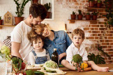 Çocukları mutfakta yemek yaparken mutlu bir aile.