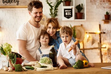 Çocukları mutfakta yemek yaparken mutlu bir aile.