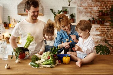 Çocukları mutfakta yemek yaparken mutlu bir aile.
