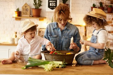 Çocukları mutfakta yemek yaparken mutlu bir aile.
