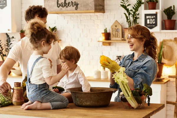 Çocukları mutfakta yemek yaparken mutlu bir aile.