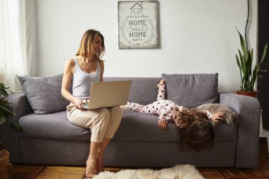 Karantina sırasındaki kadın rahat bir ev ortamında çalışıyor.