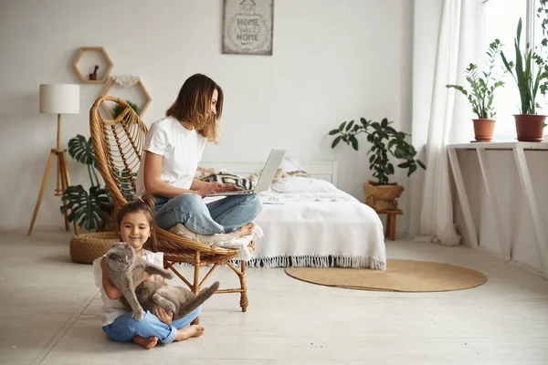 Dochter Speelt Met Mam Kat Terwijl Mam Werkt Computer — Stockfoto