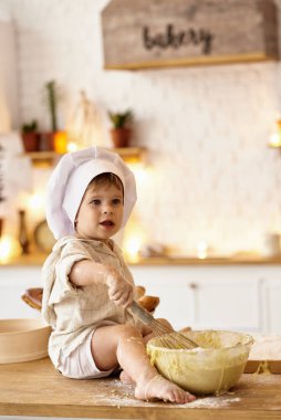 Çocuk mutfakta oynuyor.