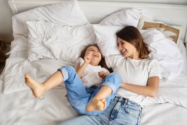 Anne bilgisayar başında çalışırken kız anne ve kediyle oynuyor.