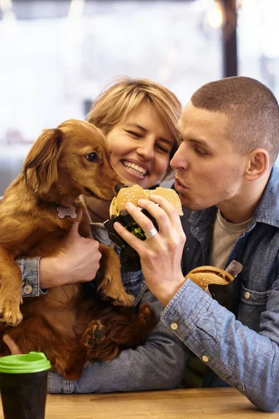 young couple with dog having fast food lunch