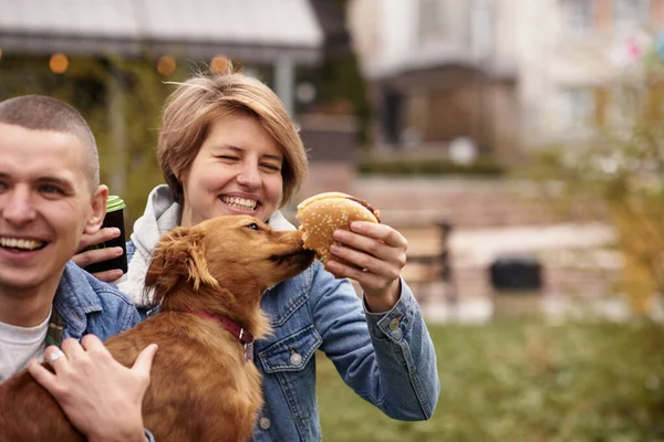 young couple with dog having fast food lunch