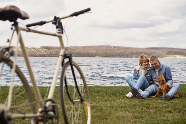 Pareja Joven Bicicleta Descansando Junto Lago Jugando Con Mascota —  Fotos de Stock
