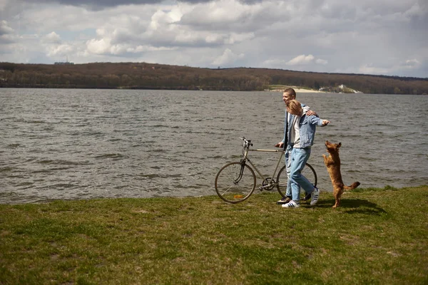 Молодая Пара Велосипеде Отдыхает Озера Играя Своим Питомцем — стоковое фото
