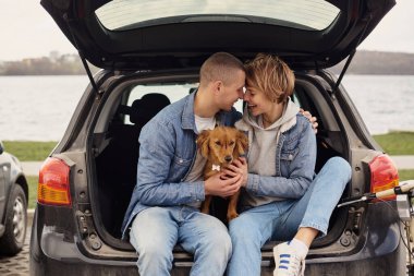 Genç çift köpekleriyle arabada dinleniyor..