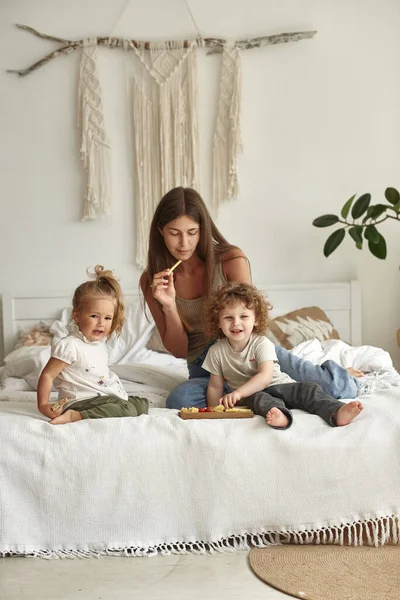 Los Niños Acuestan Cama Con Madre Comen Trozos Queso —  Fotos de Stock