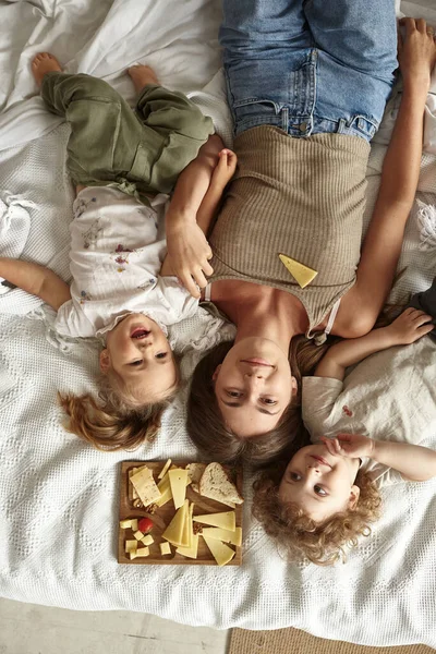 Die Kinder Liegen Mit Ihrer Mutter Auf Dem Bett Und — Stockfoto