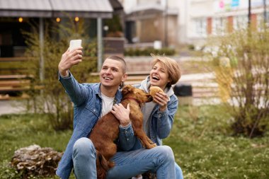 Köpekli genç çift fast food yiyor.