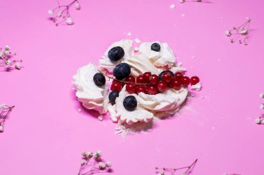 Böğürtlenli kremalı tatlı ve pembe arka planda frenk üzümü.