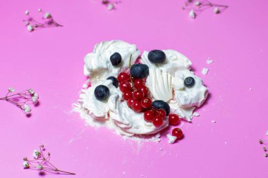 Böğürtlenli kremalı tatlı ve pembe arka planda frenk üzümü.