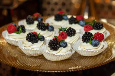 Böğürtlenli kremalı tatlı ve pembe arka planda frenk üzümü.