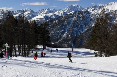 Fransız kayak merkezi Montgenevre 'de kayak ve snowboard yapan bir grup insan. Fransa 'nın Provence-Alpes-Cte d' Azur bölgesindeki güzel ağaçlı piste ve karlı kış dağlarına.