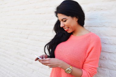 Cep telefonunu kullanan genç latin kadın