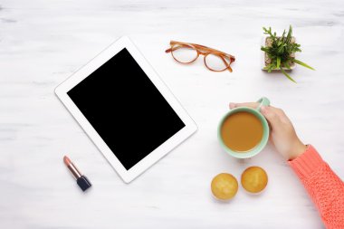 Tablet gadget, fincan kahve ve kek ve bir woode ruj