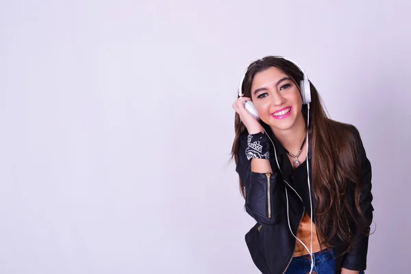 Mujer hispana joven escuchando música con auriculares —  Fotos de Stock