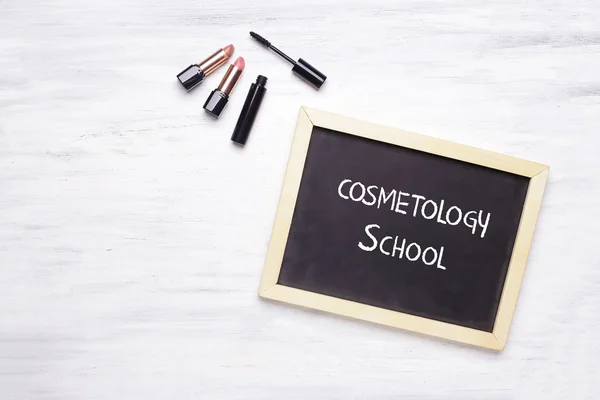 Chalkboard with Cosmetology School written on it, and cosmetic p — Stock Photo, Image