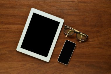 Ahşap ta tablet bilgisayar, akıllı telefon ve gözlük üst görünümü