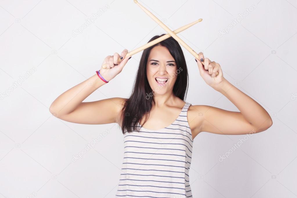 Stylish and trendy young woman holding drum sticks