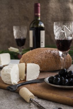 Bir şişe şarap, peynir ve beyaz ekmek üzerinde Sivas'tan vardır