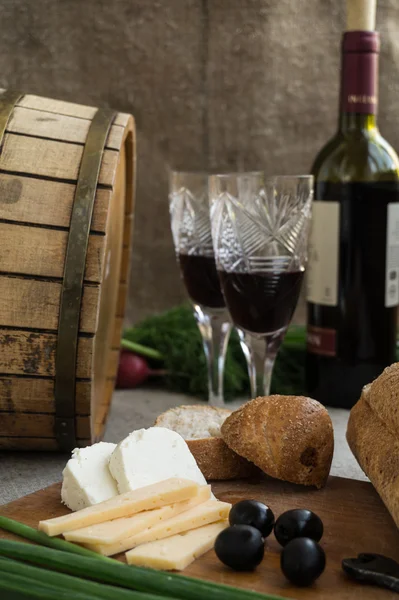 Bottle of wine, cheese and white bread are on sacking — Stock Photo, Image