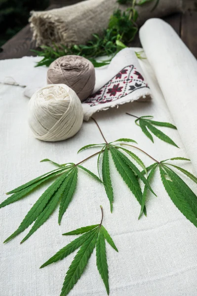 Hojas de cannabis y bolas de hilo sobre lienzo — Foto de Stock
