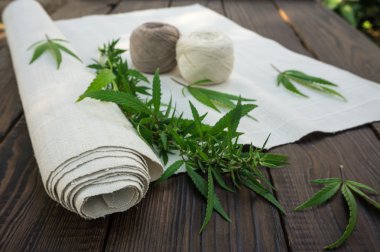 Kenevir ve kenevir kumaş yaprakları koyu ahşap surfac üzerinde rulo