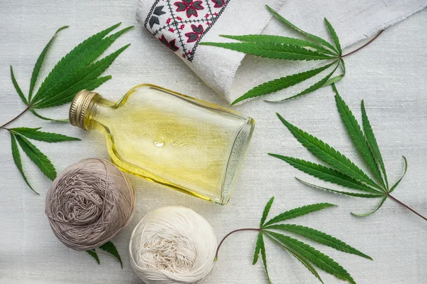 Hojas de cannabis, bolas de hilo y botella con óleo sobre lienzo — Foto de Stock