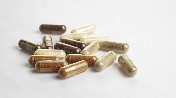 Various medical capsules on a white surface — Stock Photo, Image