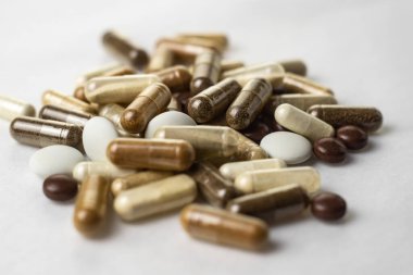 Beyaz bir yüzey üzerinde çeşitli tıbbi kapsüller