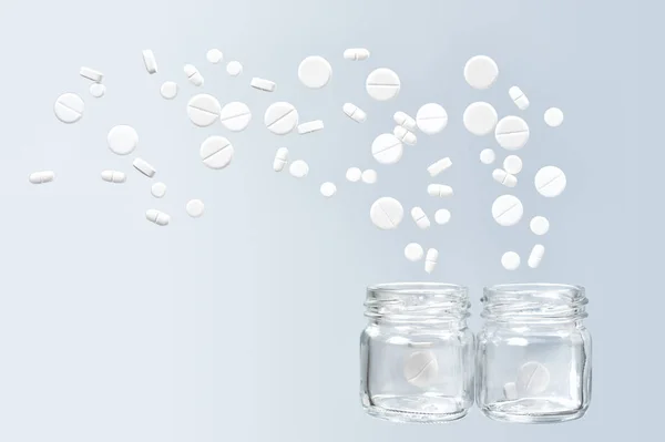 Различные Белые Медицинские Таблетки Вылетать Двух Стеклянных Банок — стоковое фото