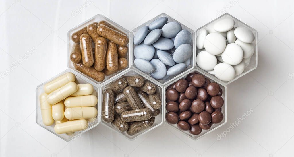 Various medical capsules and tablets in hexagonal jars in the form of honeycomb